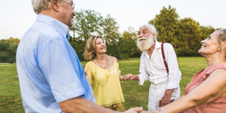 Group of Seniors Socializing Outdoors on Lawn at Independent Living Facility